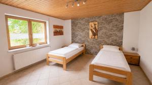 a bedroom with two beds and a window at Urlaub mit Hund auf dem Bauernhof Hofswald in Euscheid