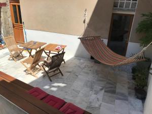 a hammock on a patio with a table and chairs at La maison aux volets bleus in Laval