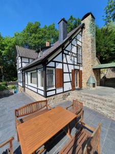 a house with a wooden table in front of it at Ferienhaus am Rursee - Haus Eiche in Simmerath