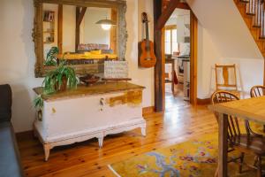 a room with a mirror and a table and a guitar at Le Triangle de l'île - Chambre La Jardin in Saint-Laurent-de-l'ile d'Orleans