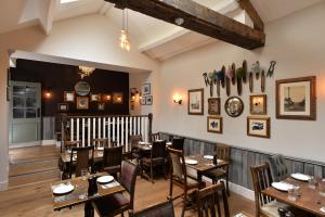 a dining room with wooden tables and chairs at The Woolly Sheep Inn in Skipton