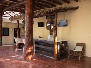 a bar in a room with a table and chairs at Chuk-Kay by ÓOL Hotels in Holbox Island