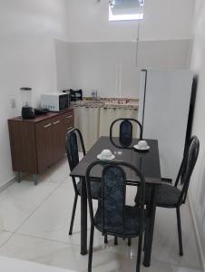a black table and chairs in a kitchen at Suíte Lençóis - Quarto amplo com Cozinha Integrada in Lençóis