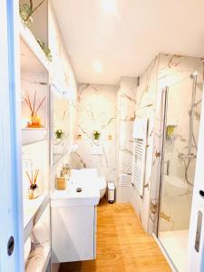 a bathroom with a white sink and a shower at Casa Sud Menton vue mer exceptionnelle terrasse parking inclus climatisation in Menton +78 photos