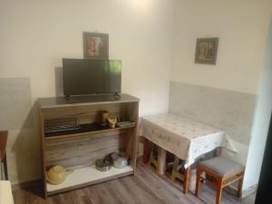 a living room with a tv and a table and a stool at borjomi downtown in Borjomi