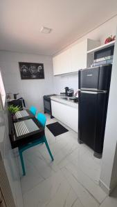 a kitchen with a black refrigerator and a table and chairs at Freedom Rooftop - Temos Wallbox 7kW para EV in Garanhuns