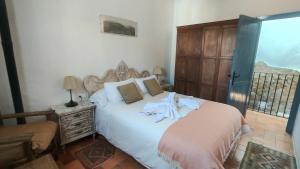a bedroom with a bed with a robe on it at Casa Dulce in Vejer de la Frontera
