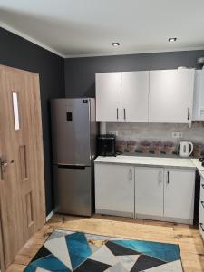 eine Küche mit weißen Schränken und einem Kühlschrank in der Unterkunft Potok in Walim