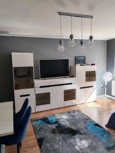 ein Wohnzimmer mit einer weißen Unterhaltungselektronikwand und einem Fernseher in der Unterkunft Potok in Walim