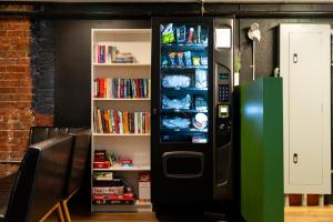 a black refrigerator is next to a book shelf at Samesun Vancouver in Vancouver