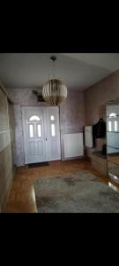 a large room with a door and a chandelier at Panorama View in Niš +3 photos