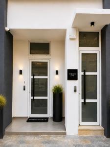 a building with two doors and two potted plants at Cabana Condo in Ierapetra +5 photos
