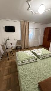 two beds in a room with a table and a tableablish at Мотель Ріта in Berehove