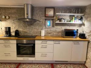 a kitchen with white cabinets and a stove at Old town Stylish Stonehouse Kauba 6a in Kuressaare