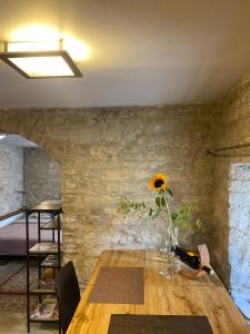 a table with a vase with a sunflower on it at Old town Stylish Stonehouse Kauba 6a in Kuressaare
