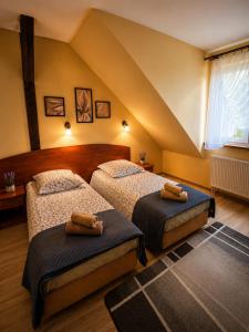 a bedroom with two beds in a attic at Zajazd Alicja in Nowe Bagienice