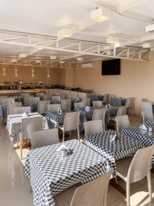 a dining room with tables and chairs with checkered tables at Hotel Cantareira in Niterói