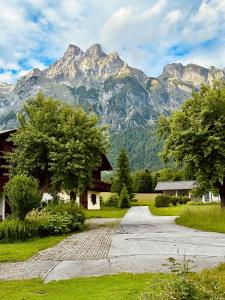 a road leading to a house with mountains in the background at Berghof Werfenweng in Werfenweng