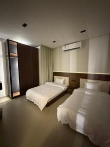 a hotel room with two beds and a window at شقق الحصن الفاخره in Al Baha