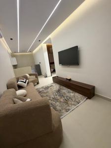 a living room with two couches and a flat screen tv at شقق الحصن الفاخره in Al Baha