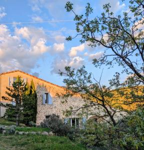 a brick house with trees in the foreground at Campagne Vallauris gites in Vaumeilh