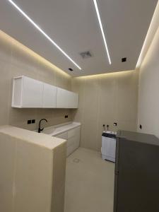 a large kitchen with white cabinets and a stove at شقق الحصن الفاخره in Al Baha +36 photos