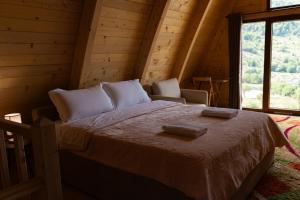 a bedroom with a bed in a log cabin at Andi's Home in Bogë