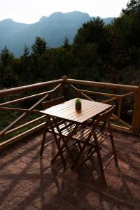 a wooden table on a balcony with a plant on it at Andi's Home in Bogë