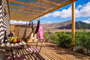 a wooden deck with a table and chairs on it at Aloha Studio in La Oliva