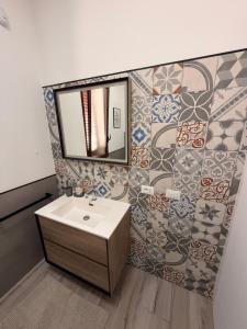 a bathroom with a sink and a mirror and tiles at Villa Marina Luxury in Balestrate +16 photos