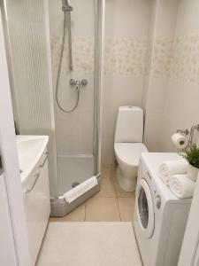 a bathroom with a shower and a washing machine at Kopų gatvės studija Nidoje in Nida