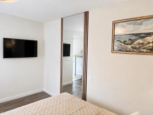 a bedroom with a mirror and a tv at Kopų gatvės studija Nidoje in Nida