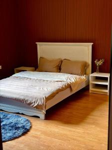 a bedroom with a white bed with a wooden floor at Remizovka Mount in Almaty