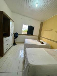 a hotel room with two beds and a flat screen tv at Beach House in Barra dos Coqueiros +5 photos