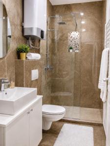 a bathroom with a shower and a toilet and a sink at Galaxy Apartments in Belgrade