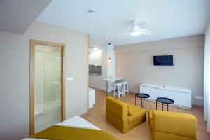 a living room with a yellow couch and a table at Estudios Aránzazu in Santander