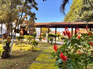 a garden with red flowers and a pavilion at Comunidade Anuncia-Me in Guaratinguetá