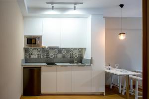 a kitchen with white cabinets and a counter top at Estudios Aránzazu in Santander