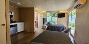 a room with two beds and a kitchen with a window at Alojamiento Zapallar in Curicó