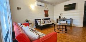 a living room with a red couch and a table at Alojamiento Zapallar in Curicó