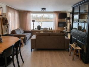 a living room with a couch and a table at Vechtdalchalet, De Wilg in Rheezerveen