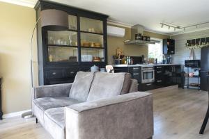 a living room with a couch and a kitchen at Vechtdalchalet, De Wilg in Rheezerveen +55 photos