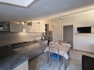 a kitchen with a table with chairs and a stove at Domus Enricucciu in Lanusei
