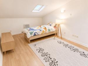 a small bedroom with a bed and a rug at sejour climatisé avec chambres avec ventilateurs in Bourgoin