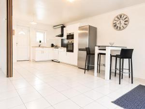 a kitchen with a table and a clock on the wall at sejour climatisé avec chambres avec ventilateurs in Bourgoin