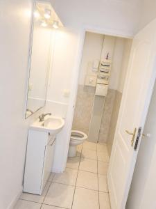 a white bathroom with a toilet and a sink at sejour climatisé avec chambres avec ventilateurs in Bourgoin