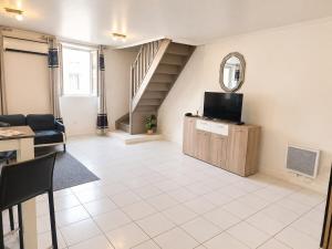 a living room with a television and a staircase at sejour climatisé avec chambres avec ventilateurs in Bourgoin