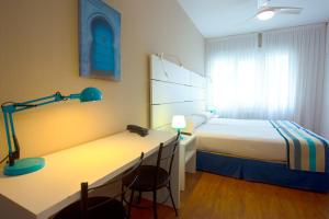 a hotel room with a bed and a desk with a bed petertodd at Estudios Aránzazu in Santander