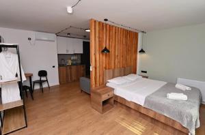 a bedroom with a large bed and a kitchen at Pine Aparthotel in Shekhvetili