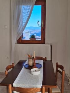 a dining room table and chairs with a window at Portitsa View Guesthouse in Spílaion